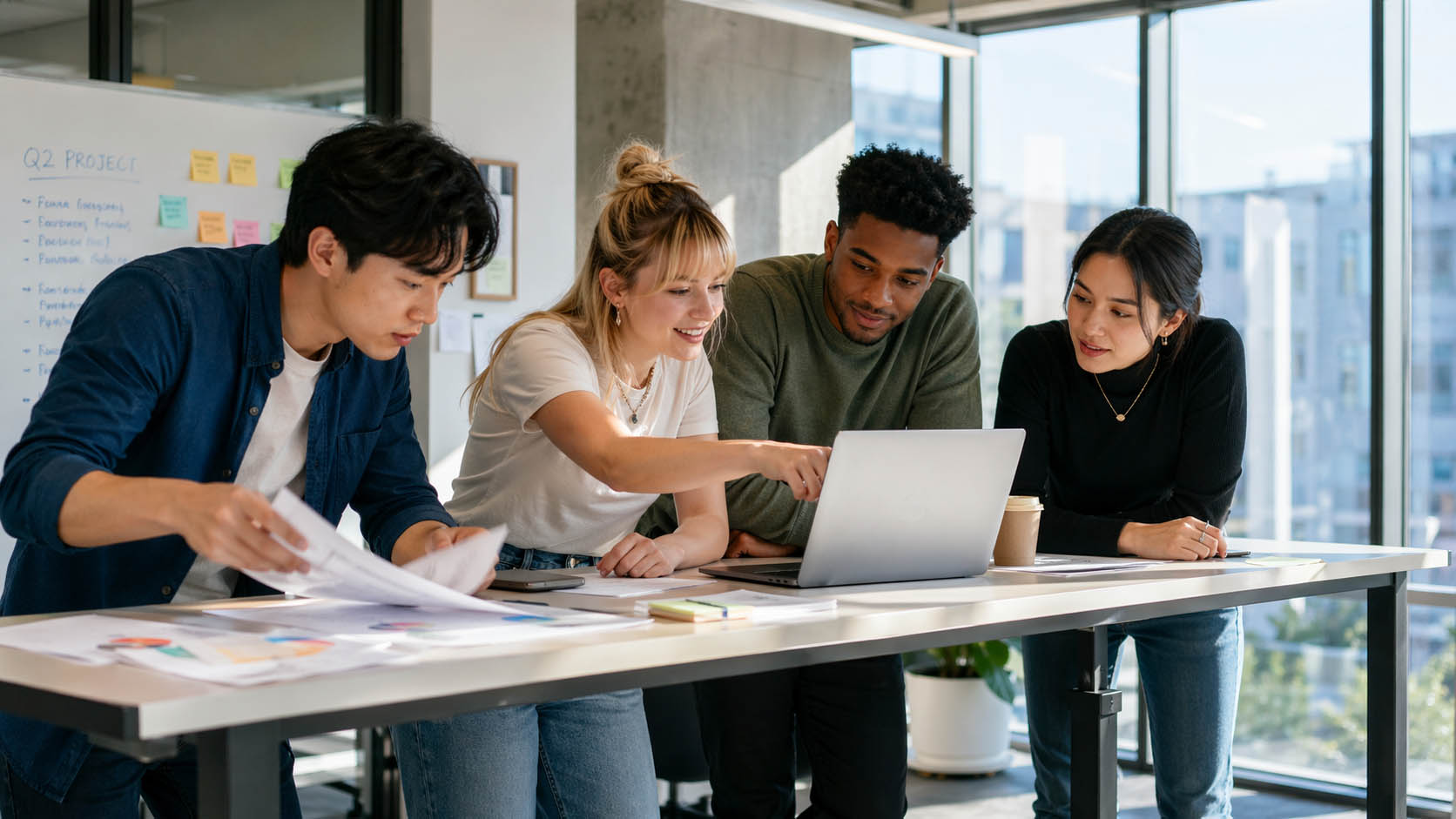 Mladi tim reaguje na promenu plana oko laptopa u kancelariji.